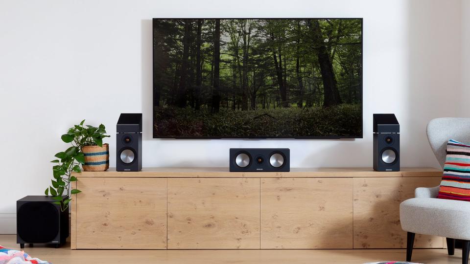 Monitor Audio speakers on a beige unit under a TV