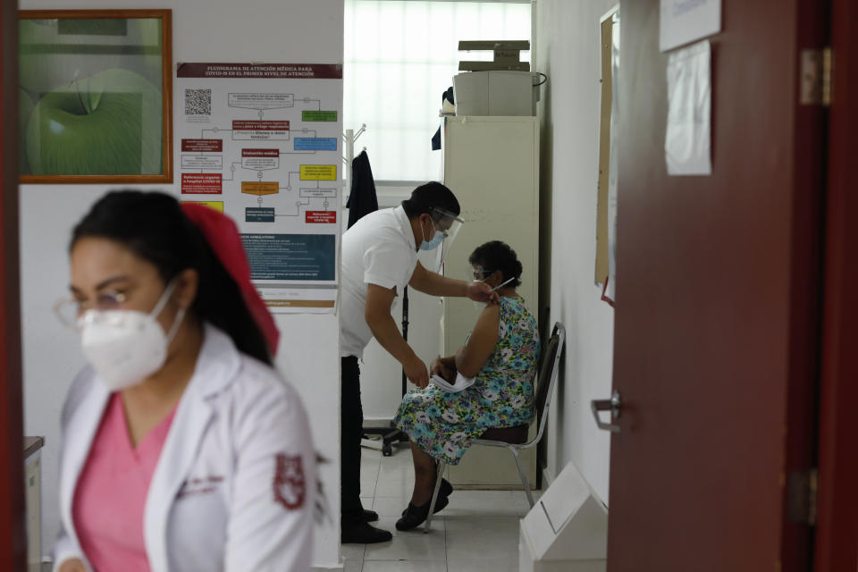 Un trabajador médico se prepara para poner a una mujer la vacuna de AstraZeneca en el distrito periférico de Milpa Alta de la Ciudad de México, el lunes 15 de febrero de 2021. México comenzó a vacunar a su población anciana contra el nuevo coronavirus. (Foto AP/Rebecca Blackwell)