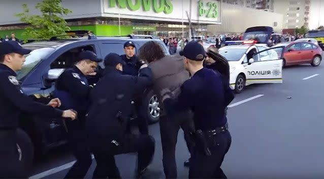 Police swarm and club him. Source: Road Control/Ukranian Pravda