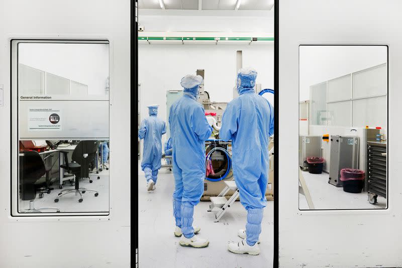 FILE PHOTO: Assembly engineers work on a TWINSCAN DUV lithography system at ASML in Veldhoven