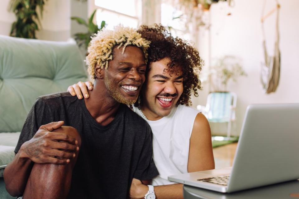 two men on a computer smiling