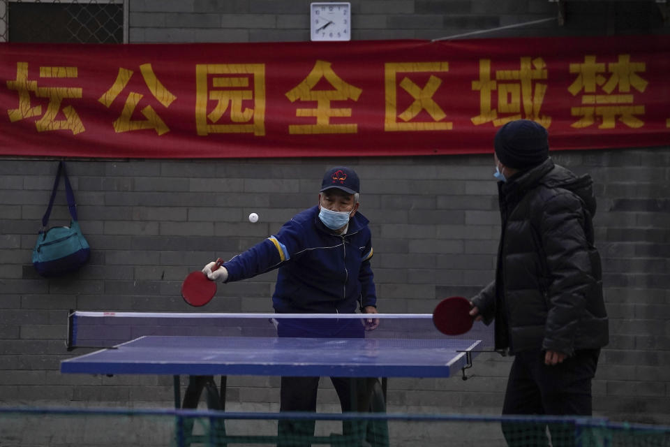 People wearing face masks to help curb the spread of the coronavirus play table tennis in the morning at a public park in Beijing, Wednesday, Dec. 9, 2020. (AP Photo/Andy Wong)
