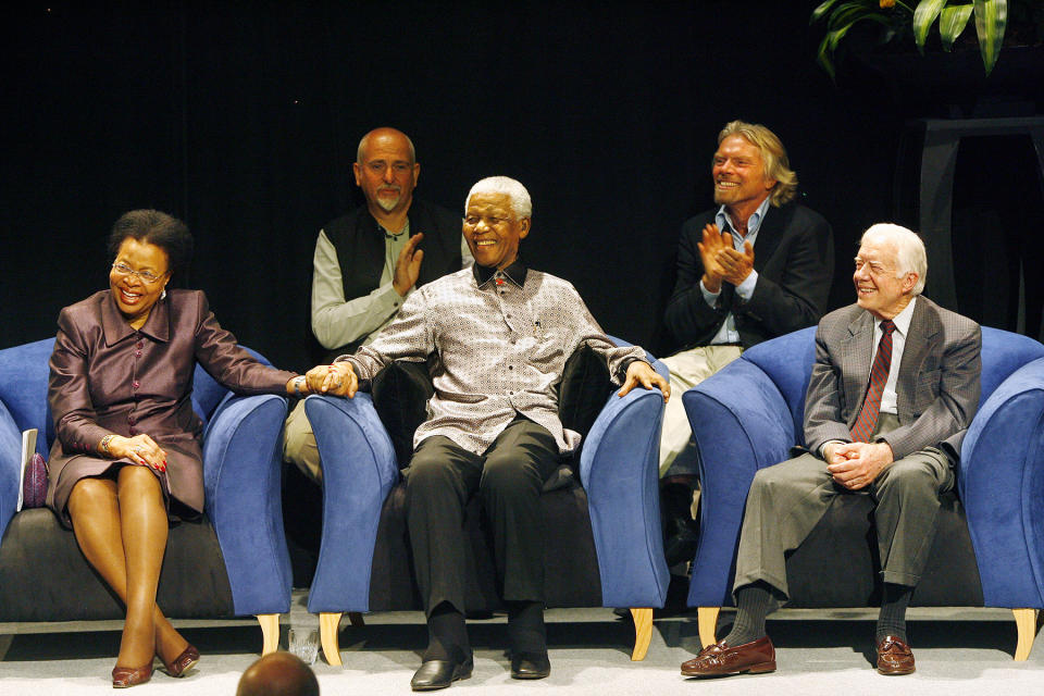 Former South African President Nelson Mandela, flanked from left, by his wife Graca Machel, British singer Peter Gabriel, British entrepreneur Richard Branson and former U.S. President Jimmy Carter, listens to South Africa's Archbishop Emeritus Desmond Tutu address the audience in Johannesburg Wednesday July 18, 2007. Mandela celebrates his 89th birthday Wednesday with a star-studded soccer match and the launch of a humanitarian campaign, joined by "elders" of the global village. (AP Photo/Jerome Delay)