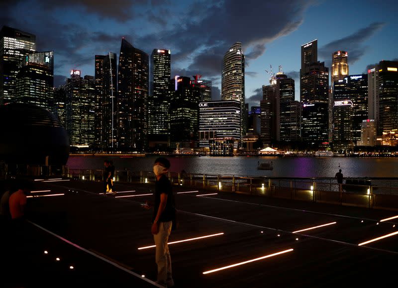 A man wearing a mask in precaution of the coronavirus looks on along the Marina Bay Waterfront Promenade in Singapore