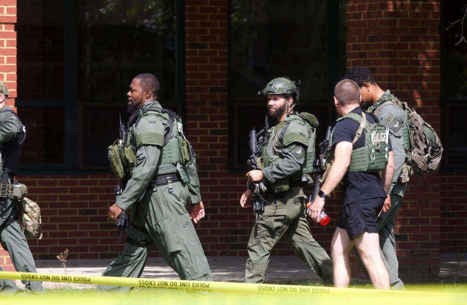 A Newport News Police Department Tactical Operations Unit patrols the perimeter of Heritage High School following a shooting, Monday, Sept. 20, 2021, in Newport News, Va. (Kaitlin McKeown/The Virginian-Pilot via AP)