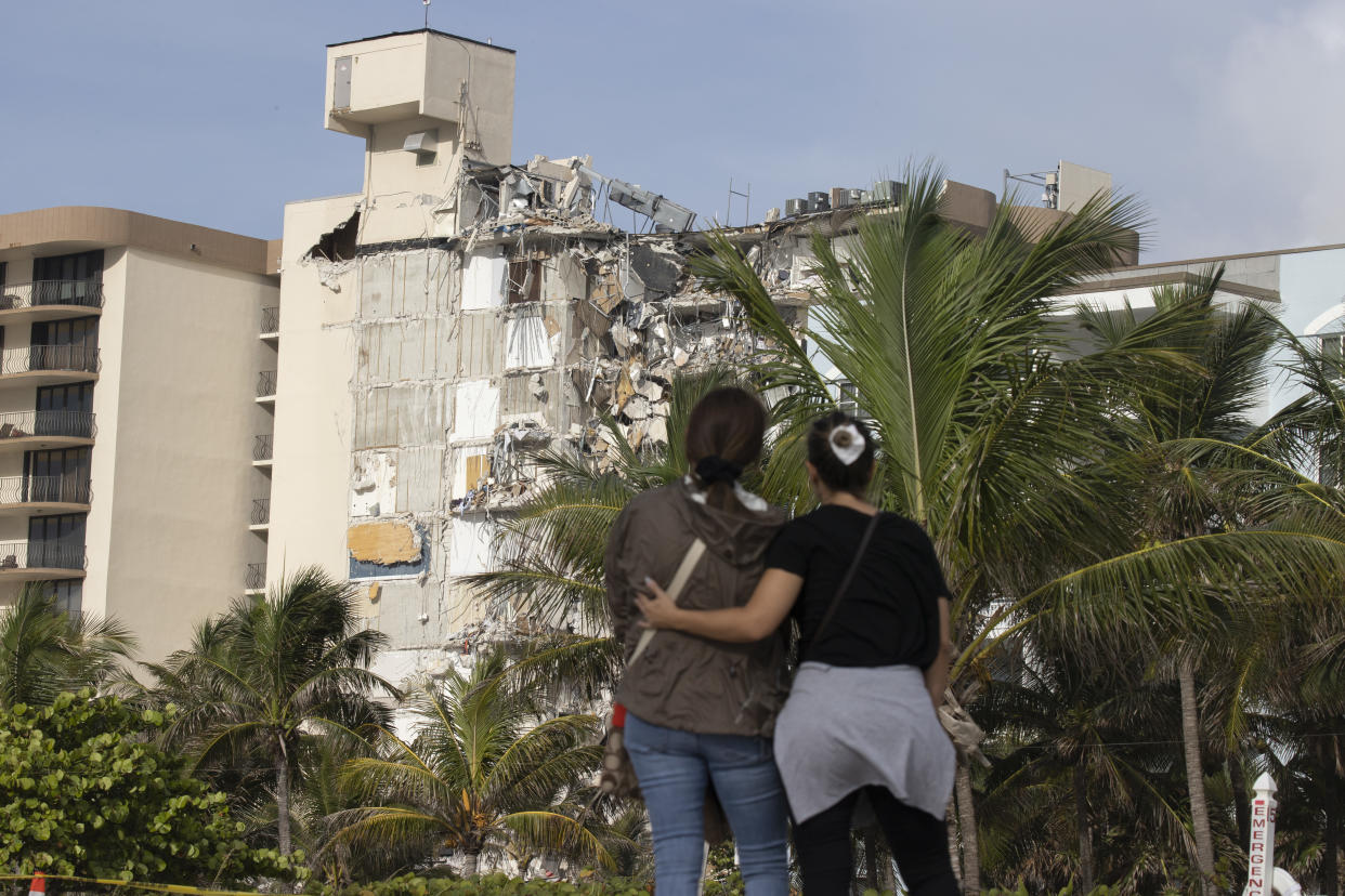 SURFSIDE, FLORIDA - JUNE 25: Maria Fernanda Martinez and Mariana Cordeiro (L-R) look on as search and rescue operations continue at the site of the partially collapsed 12-story Champlain Towers South condo building on June 25, 2021 in Surfside, Florida. Over one hundred people are being reported as missing as search-and-rescue effort continues with rescue crews from across Miami-Dade and Broward counties. (Photo by Joe Raedle/Getty Images)