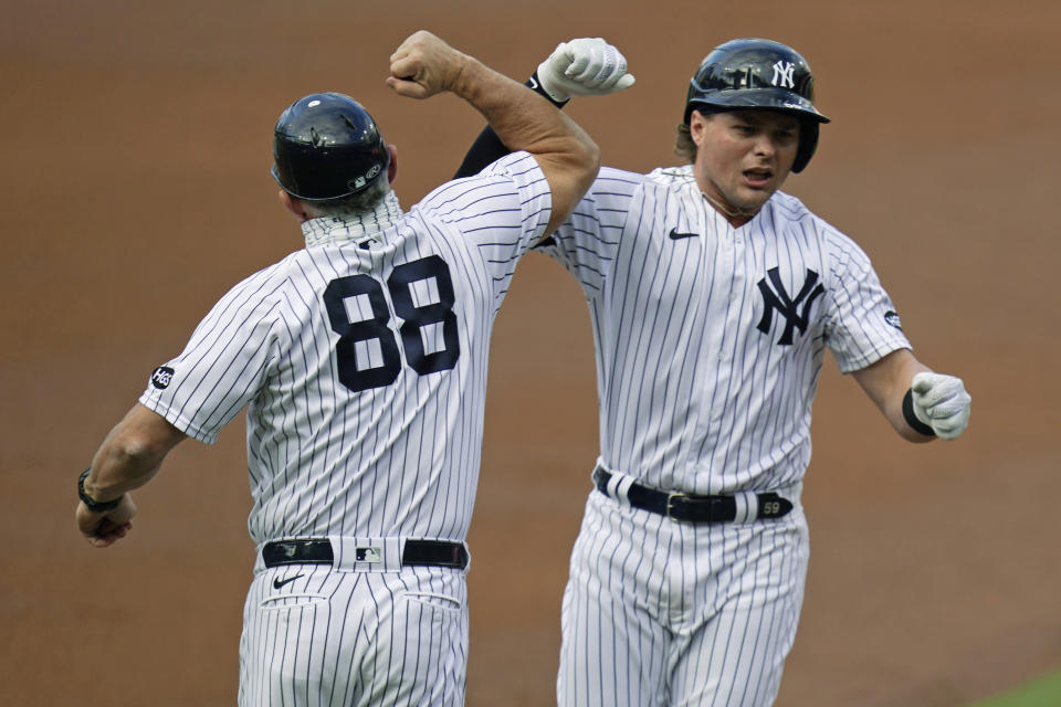 New York Yankees first baseman Luke Voit, right, celebrates with third base coach Phil Nevin (88) after Voit hit a solo home run against the Tampa Bay Rays during the second inning in Game 4 of a baseball American League Division Series Thursday, Oct. 8, 2020, in San Diego. (AP Photo/Gregory Bull)