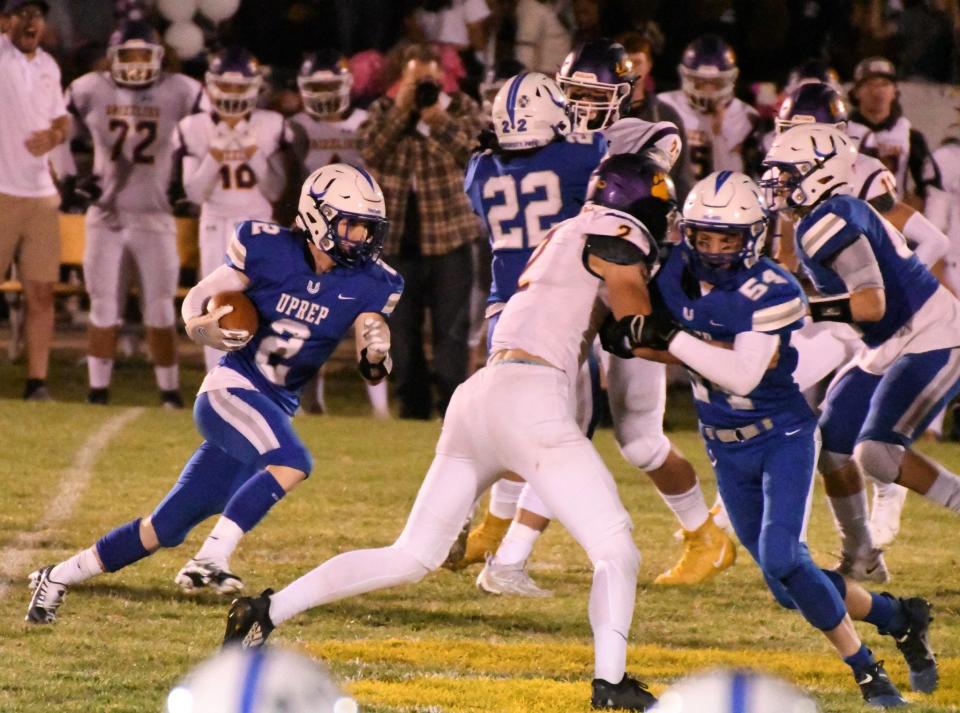 U-Prep senior running back Mason Cassingham (left) gets blocks from junior guard Caleb Marks (right) and senior running back Ryan Dyab (back) during his team's 21-7 win on the road against Lassen on Friday, Oct. 7, 2022.