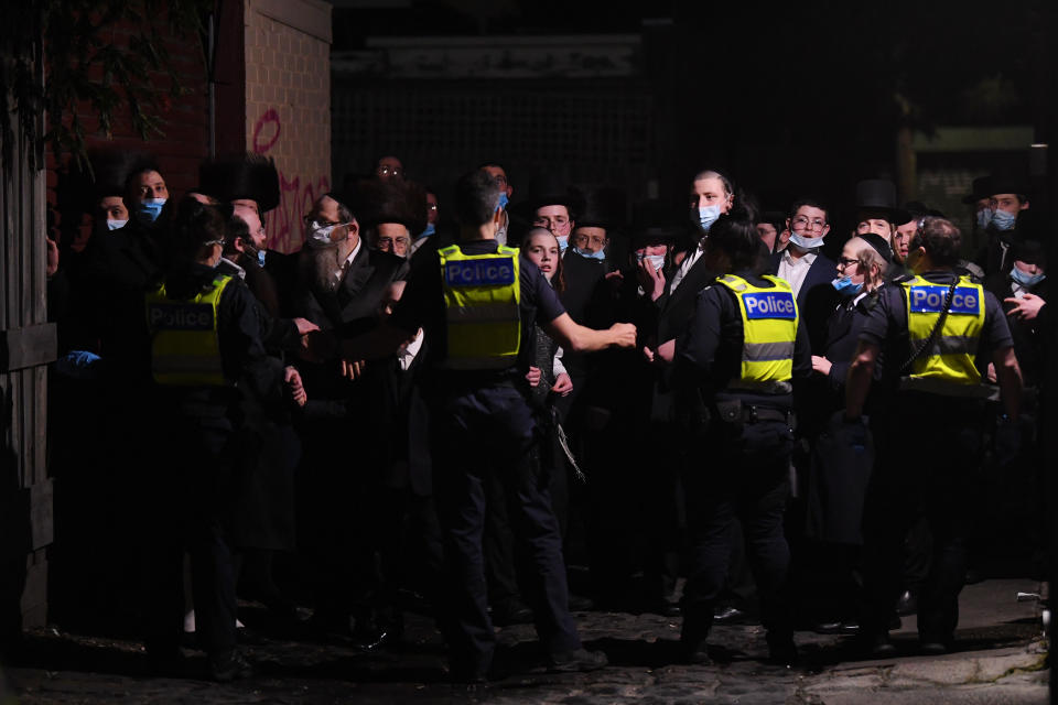 Victoria Police stand guard outside of building near a Ripponlea synagogue in Melbourne on Tuesday night after an illegal gathering. Source: Getty