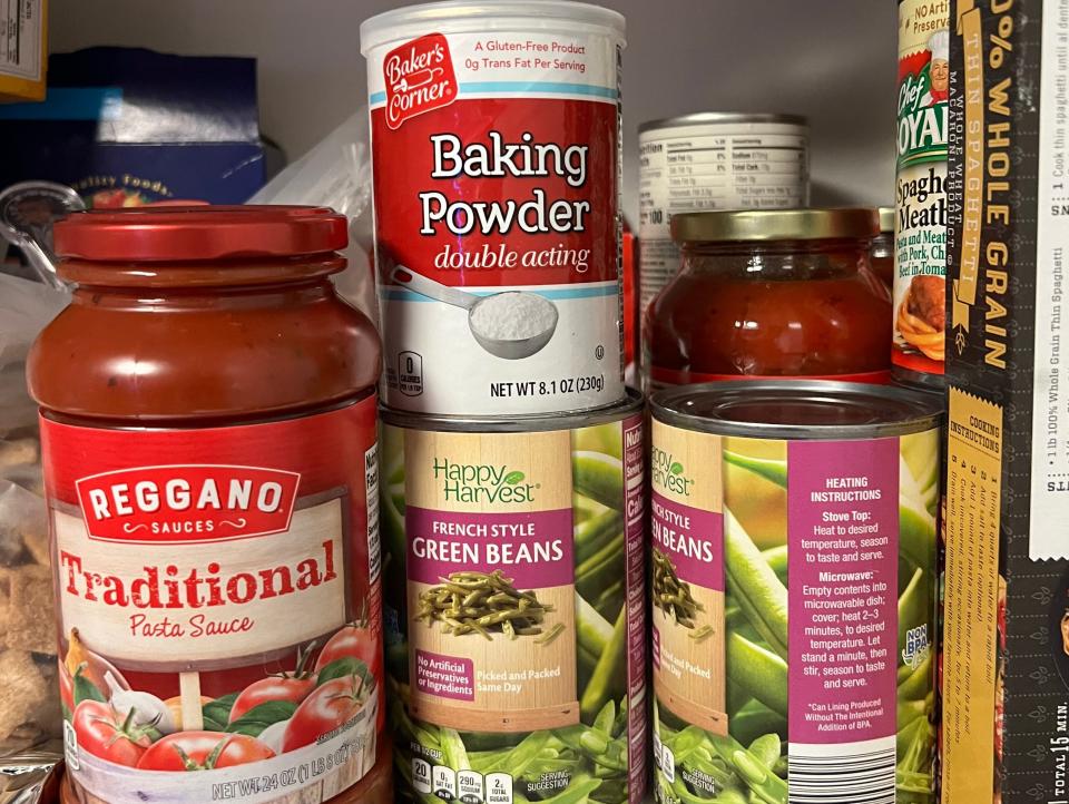 Baking powder, Reggano tomato sauce, and canned green beans in a pantry