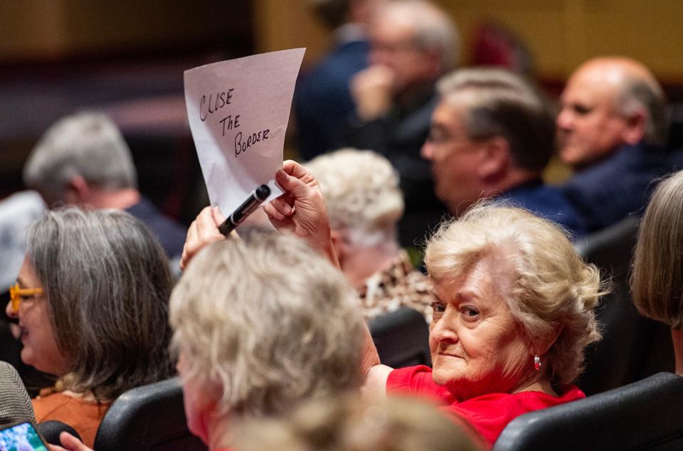 Carol Frazier holds up a sign that reads "Close the border" before the event featuring Speaker of the House Mike Johnson began at Jackson Preparatory School in Flowood on Thursday. "I'm just totally disappointed in the man," Frazier said of Speaker Johnson. "He speaks like he's a good Christian. How can you be a good Christian and know there are all these people coming in to do us harm?"