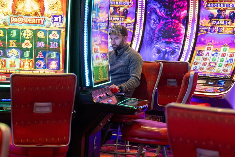 A patron plays colorful gaming machines