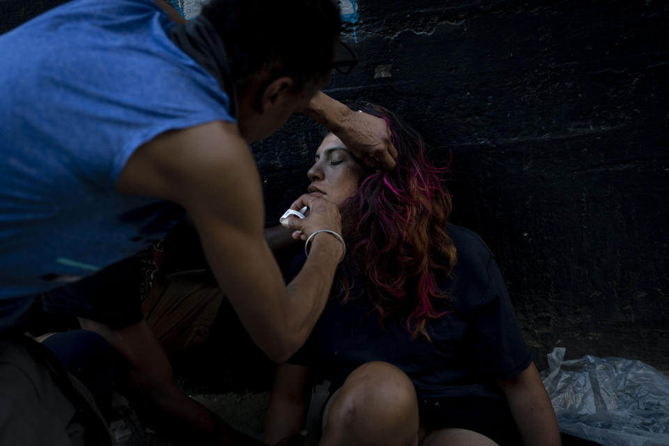 A homeless man injects a Narcan nasal spray into the nose of a female addict who appears to be overdosed in Los Angeles, Thursday, Aug. 25, 2022. For too many people strung out on the drug, the sleep that follows a fentanyl hit is permanent. The highly addictive and potentially lethal drug has become a scourge across America and is taking a toll on the growing number of people living on the streets of Los Angeles. (AP Photo/Jae C. Hong)