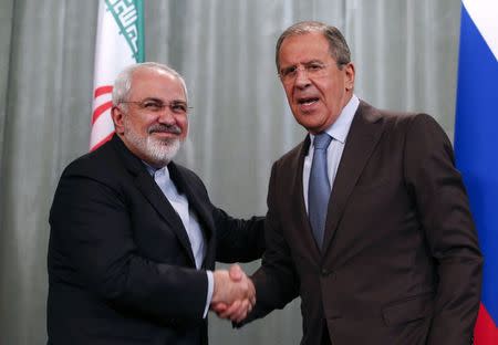 Iranian Foreign Minister Mohammad Javad Zarif (L) and his Russian counterpart Sergei Lavrov shake hands as they attend a news conference in Moscow, August 29, 2014. REUTERS/Maxim Zmeyev