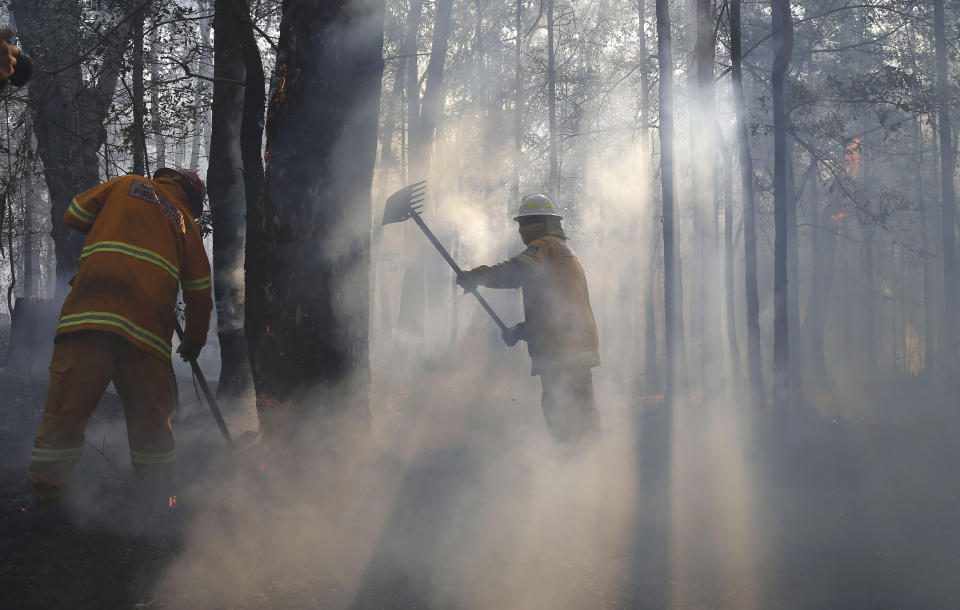 Firefighters mop up and check for reflash after a firestorm swept through a property in Bilpin, 75 kilometers (47 miles) from Sydney, Wednesday, Oct. 23, 2013. Scores of Australians evacuated their homes in mountains west of Sydney on Wednesday as intensifying winds fanned wildfires and grounded the helicopters that were fighting them. (AP Photo/Rob Griffith)
