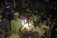 Ethnic Rohingya people rest after the boat carrying them landed in Lhokseumawe, Aceh province, Indonesia, early Monday, Sept. 7, 2020. Almost 300 Rohingya Muslims were found on a beach in Indonesia's Aceh province Monday and were evacuated by military, police and Red Cross volunteers, authorities said. (AP Photo/Rahmat Mirza)