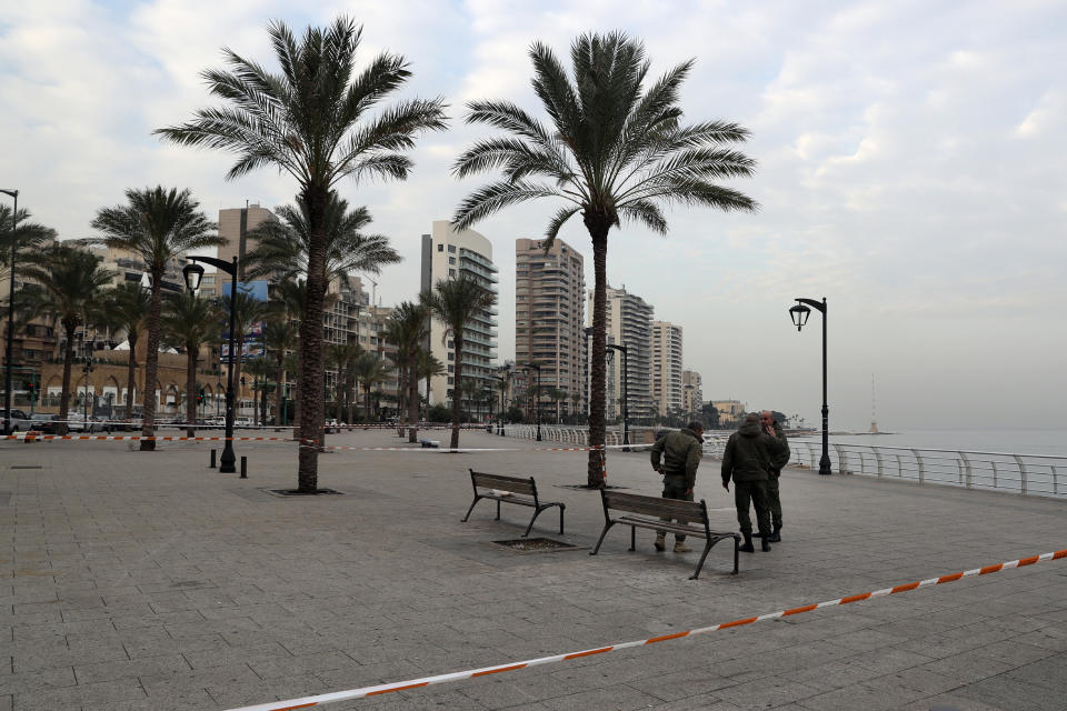 Police stand guard on the waterfront promenade as the country begins a three-week lockdown to limit the spread of coronavirus amid a post-holiday surge in the past 10 days in Beirut, Lebanon, Thursday, Jan. 7, 2021. (AP Photo/Bilal Hussein)