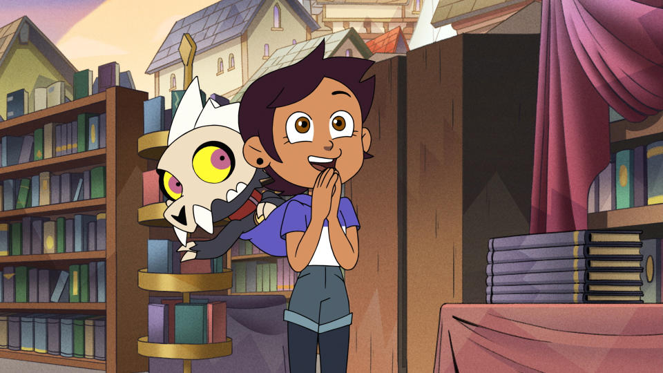 (L to R) King sits on Luz's shoulder waving as Luz stands with an excited smile and her hands clasped together in The Owl House Episode 