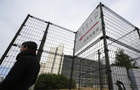 A journalist stands outside Tokyo Detention Center where former Nissan chairman Carlos Ghosn is being detained, Monday, Dec. 10, 2018, in Tokyo. Tokyo prosecutors say Ghosn, who was arrested on Nov. 19, is suspected of underreporting income by 5 billion yen ($44 million) over five years. Japanese media are reporting that the government Securities and Exchange Surveillance Commission is accusing Nissan as a company, along with Ghosn and another executive, of underreporting income. (AP Photo/Eugene Hoshiko)