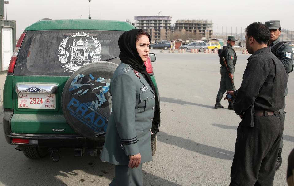 Afghanistan's first-ever female district police chief, Col. Jamila Bayaz, 50, center, walks as she review a check post in Kabul, Afghanistan, Thursday, Jan. 16, 2014. Afghanistan's first-ever female district police chief drew stares on Thursday as she drove and walked around the center of the city, reviewing check points and some of the important business and administrative facilities she is tasked with protecting. (AP Photo/Massoud Hossaini)