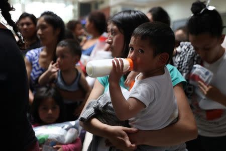 Undocumented immigrant families look on as they are released from detention at a bus depot in McAllen, Texas, U.S., June 22, 2018. REUTERS/Loren Elliott