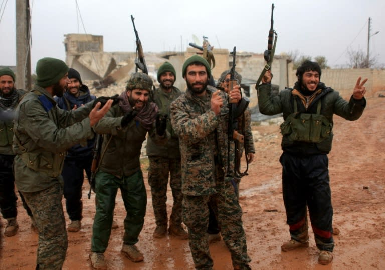 Syrian government soldiers celebrate after taking control of the village of Ratian, north of the embattled city of Aleppo, from rebel fighters on February 6, 2016