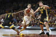 Minnesota's Alihan Demir handles the ball through the defense of Iowa's Joe Toussaint (1) and Luka Garza (55) during an NCAA college basketball game Sunday, Feb. 16, 2020, in Minneapolis. (AP Photo/Stacy Bengs)