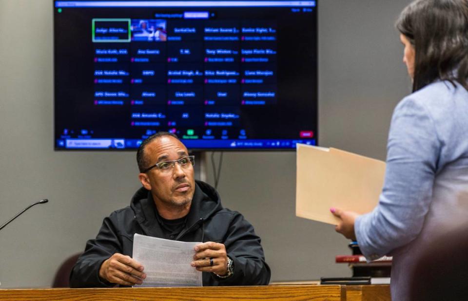 La abogada defensora Beatriz Llorente entrega algunos documentos al detective Fernando Carvajal, mientras lo interroga, durante una audiencia previa al juicio del acusado Oscar Olea en el Gerstein Justice Building, en Miami, el jueves 7 de marzo de 2024. Pedro Portal/pportal@miamiherald.com