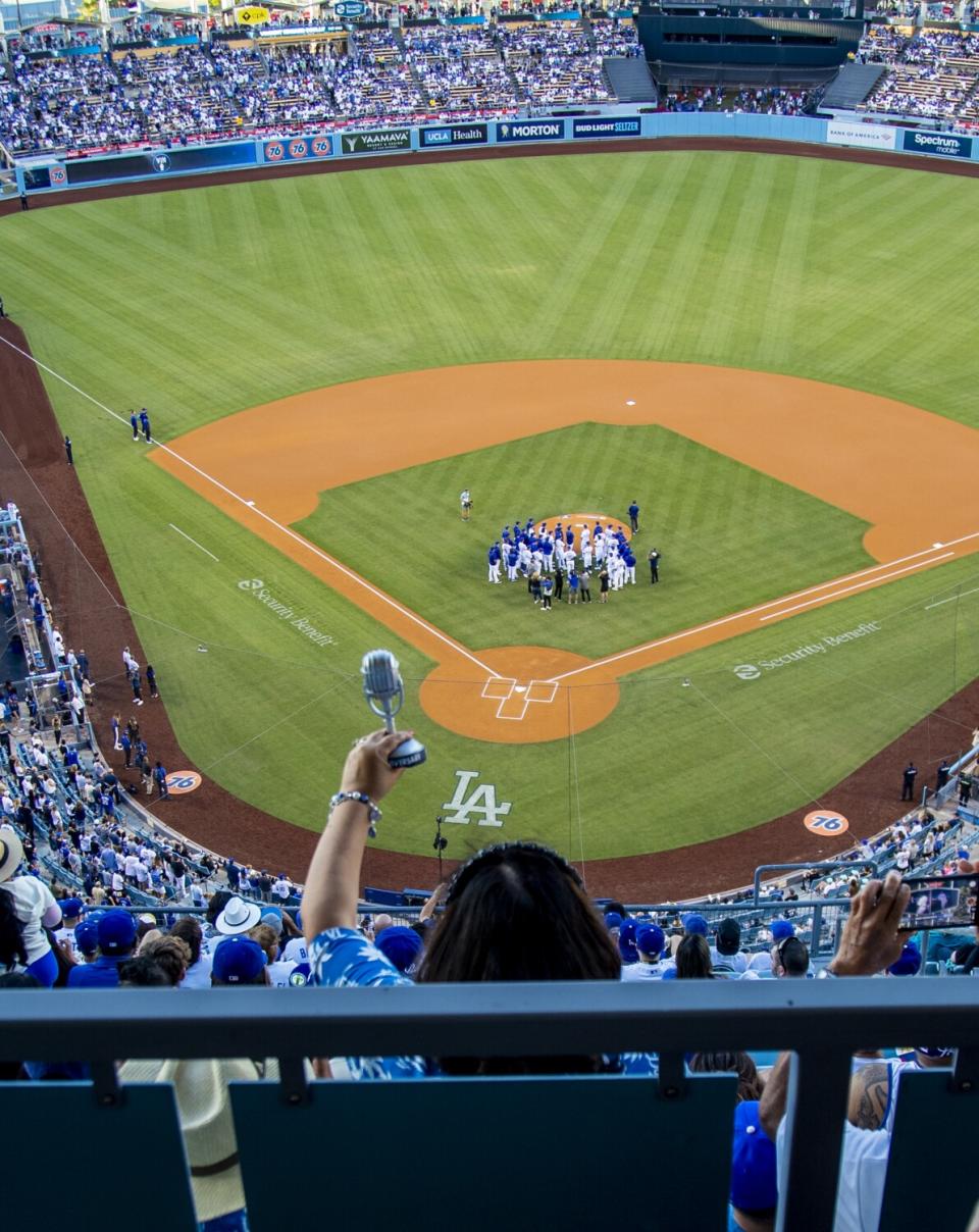 Dodgers fan Angie Varella holds a replica microphone during a tribute to Vin Scully.