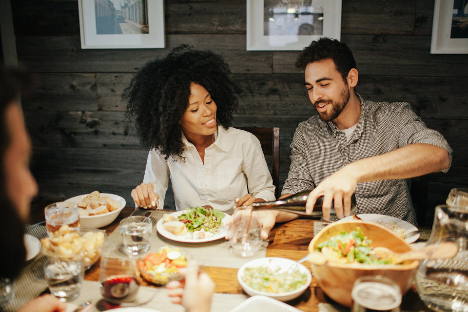 If you can't go, consider having your engaged friends over for a dinner party before or after the wedding. (Photo: EasyPx via Getty Images)