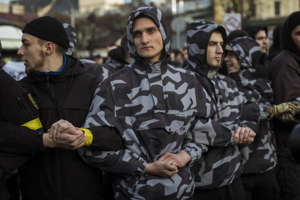 Members of right-wing National Corps march toward an election campaign rally of Petro Poroshenko, President of Ukraine and candidate for 2019 elections, in Lviv, Ukraine, Thursday, March 28, 2019. Presidential elections will be held in Ukraine on 31 March 2019. (AP Photo/Emilio Morenatti)