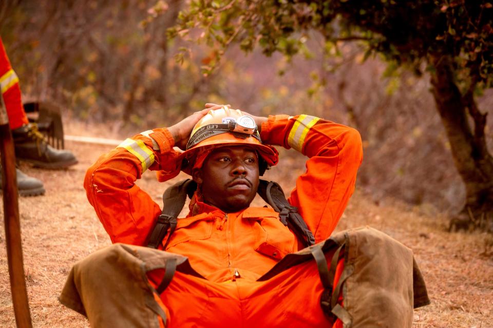 An inmate firefighter rests during a break from battling the River Fire in Salinas, Calif., Monday, Aug. 17, 2020. Fire crews across the region scrambled to contain dozens of blazes sparked by lightning strikes as a statewide heat wave continues.