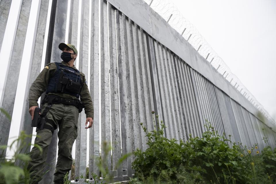 FILE - In this Friday, May 21, 2021, a policeman patrols alongside a steel wall at Evros river, near the village of Poros, at the Greek -Turkish border, Greece. Greece's prime minister and Turkey's president are to speak Friday evening, Aug. 20 to discuss "the latest developments in Afghanistan." Both countries are raising concerns about facing a potential major influx of people fleeing Afghanistan after the Taliban's takeover. (AP Photo/Giannis Papanikos, File)