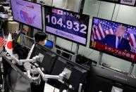 An employee of the foreign exchange trading company Gaitame.com watches a TV broadcast of U.S. President Donald Trump's speech at a dealing room in Tokyo