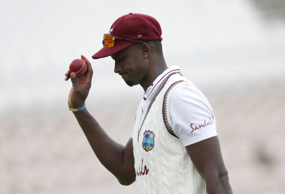 West Indies' captain Jason Holder holds up the ball as he leaves the field after taking six wickets during the second day of the first cricket Test match between England and West Indies, at the Ageas Bowl in Southampton, England, Thursday, July 9, 2020 (Adrian Dennis/Pool via AP)
