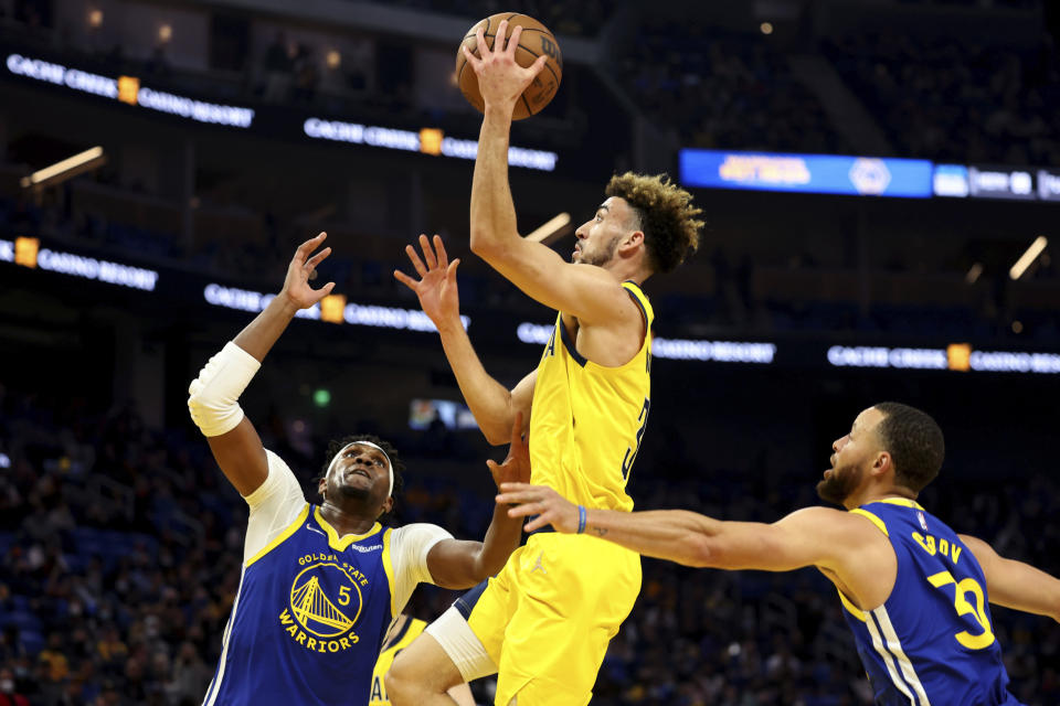 Indiana Pacers guard Chris Duarte (3) shoots against Golden State Warriors center Kevon Looney (5) and guard Stephen Curry (30) during the first half of an NBA basketball game in San Francisco, Thursday, Jan. 20, 2022. (AP Photo/Jed Jacobsohn)