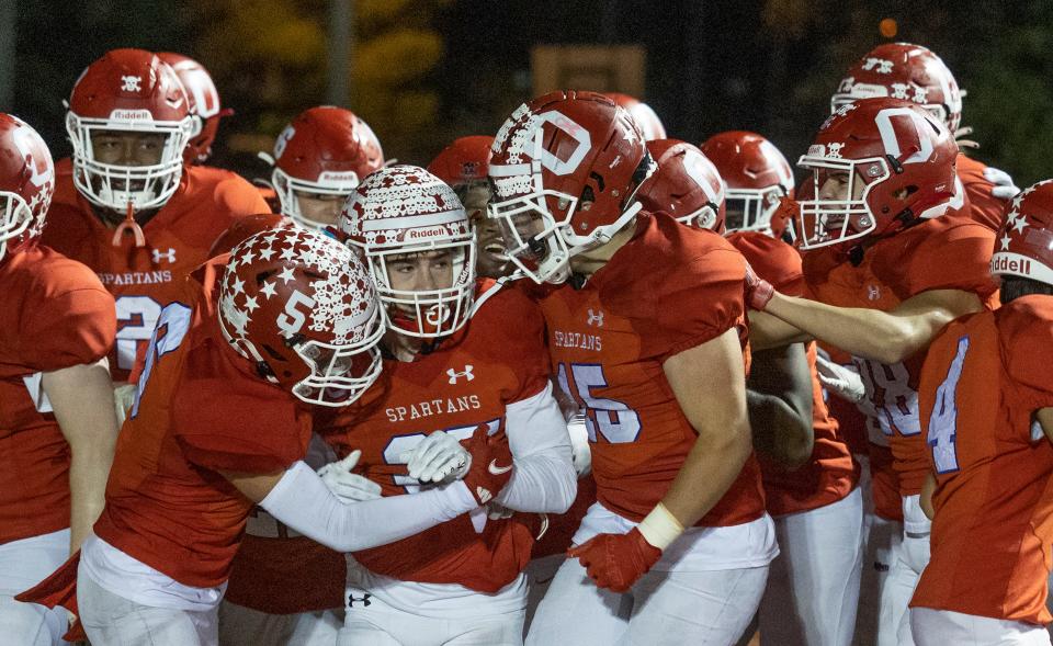 Ocean's C.J. Flannigan is surrounded by his jubilant teammates after he scored the winning TD in Ocean's 34-28 overtime win over Middletown North Friday night.