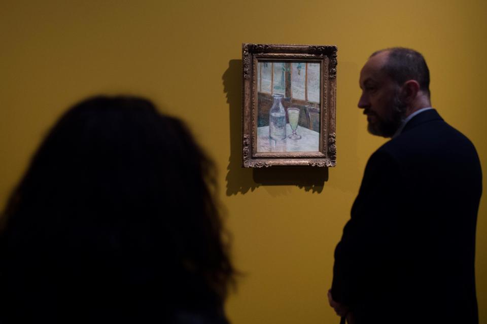 Men look at a painting by Vincent Van Gogh entitled 'Cafe Table with Absinthe' during the exhibition 'Van Gogh in Provence: Modernizing Tradition' at the Fondation Vincent Van Gogh Arles on May 13, 2016 in Arles, southern France.&nbsp;