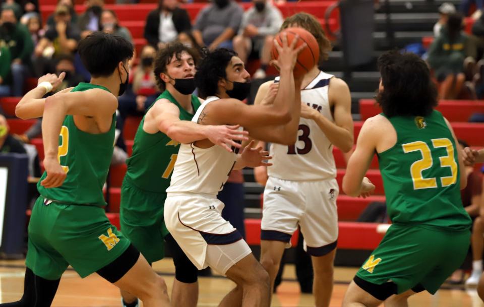 Junior Wildcat Alex Alfaro (with ball) draws a crowd of Mayfield Trojans during Friday's District 3-5A contest. Alfaro had a game-high 21 points and 11 rebounds in a 74-54 Deming High loss.