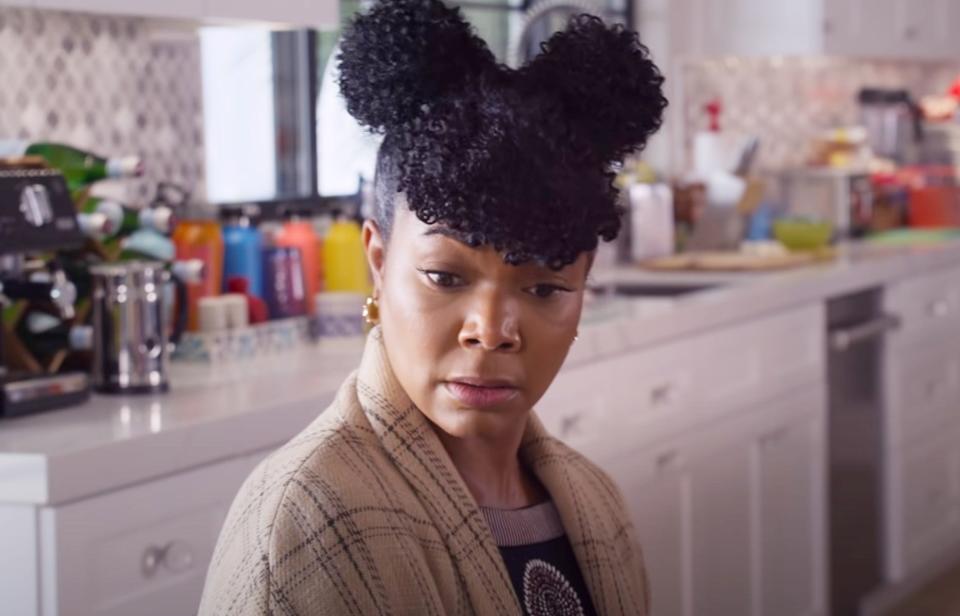 Gabrielle Union with space buns in her hair as she sits in the kitchen in "Cheaper by the Dozen"