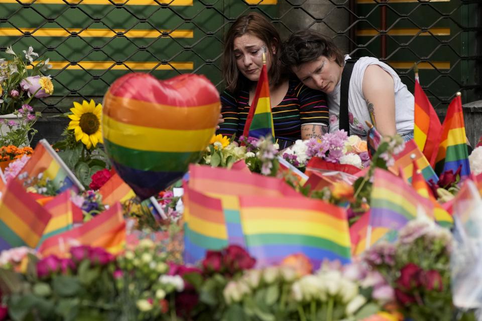 People comfort each other at the scene of a shooting in central Oslo, Norway, Saturday, June 25, 2022. A gunman who opened fire in Oslo’s nightlife district has killed two people and left more than 20 others injured during the LGBTQ Pride festival in Norway's capital. (AP Photo/Sergei Grits)