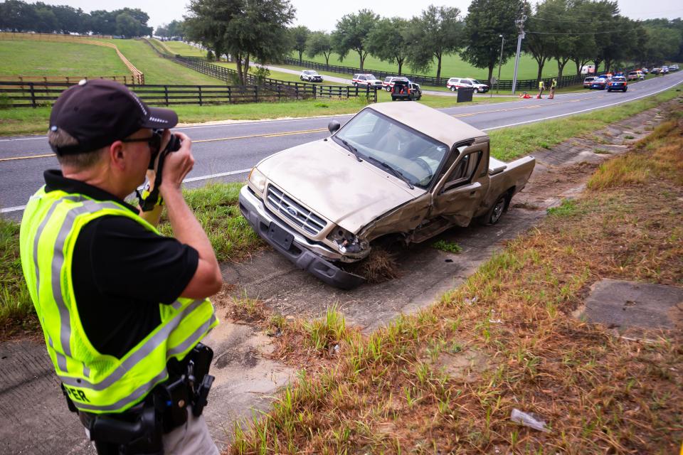 Florida Highway Patrol Cpl. Brett Detweiler takes pictures of the pickup truck that was involved in Tuesday morning's crash.