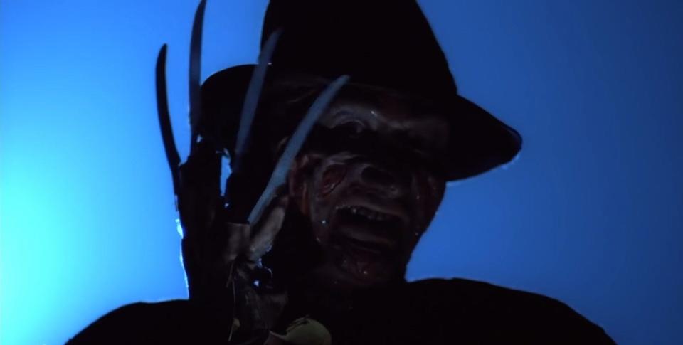 Freddy Krueger holding his knife glove over his face in "A Nightmare on Elm Street"