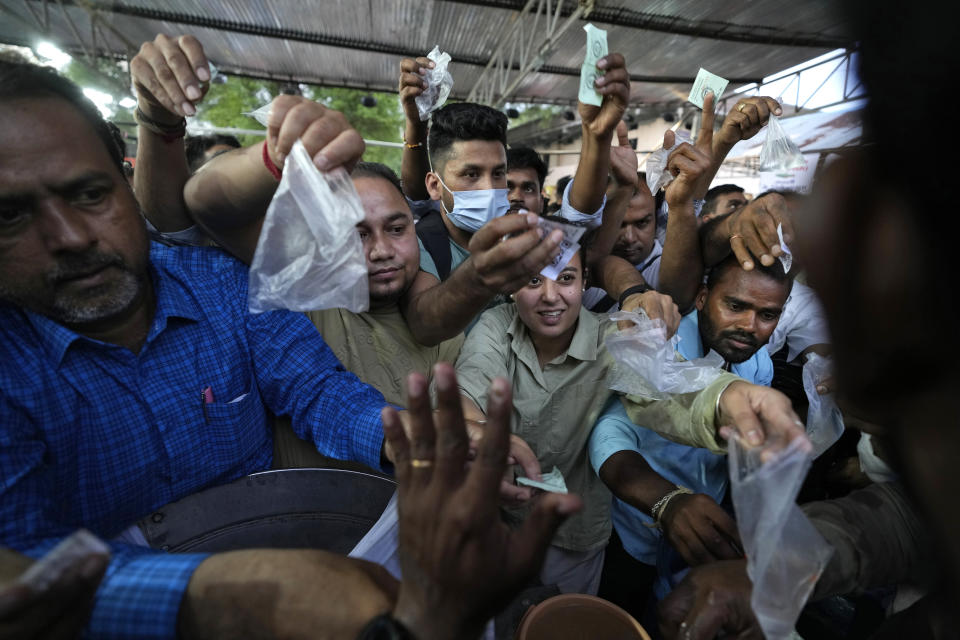 Asthma patients crowd around a fisheries stall to collect live fish to be used in a therapy for their asthma, in Hyderabad, India, Saturday, June 8, 2024. Every year thousands of asthma patients arrive here to receive this fish therapy from the Bathini Goud family, a secret formula of herbs, handed down by generations only to family members. The herbs are inserted in the mouth of a live sardine, or murrel fish, and slipped into the patient's throat. (AP Photo/Mahesh Kumar A.)