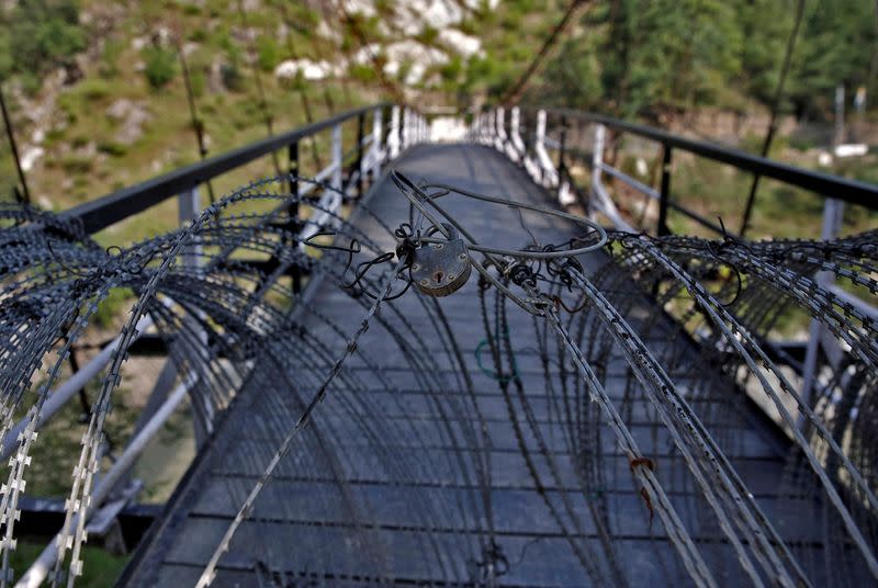 FILE PHOTO: A view shows a padlock on concertina wires on a footbridge connecting Indian administered Kashmir and Pakistan administered Kashmir in Teetwal