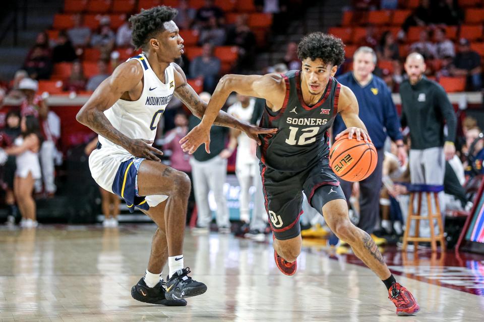 Oklahoma guard Milos Uzan (12) works past West Virginia guard Kedrian Johnson (0) in the second half during a college basketball game between the Oklahoma Sooners (OU) and the West Virginia Mountaineers at Lloyd Noble Center in Norman, Okla., Saturday, Jan. 14, 2023.