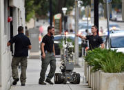 <p>Bomb squad police prepare a robot to enter a parking garage a block away from the scene of a multiple shooting at the Jacksonville Landing, Aug. 26, 2018, during a video game competition in Jacksonville, Fla. (Photo: Will Dickey/The Florida Times-Union via AP) </p>