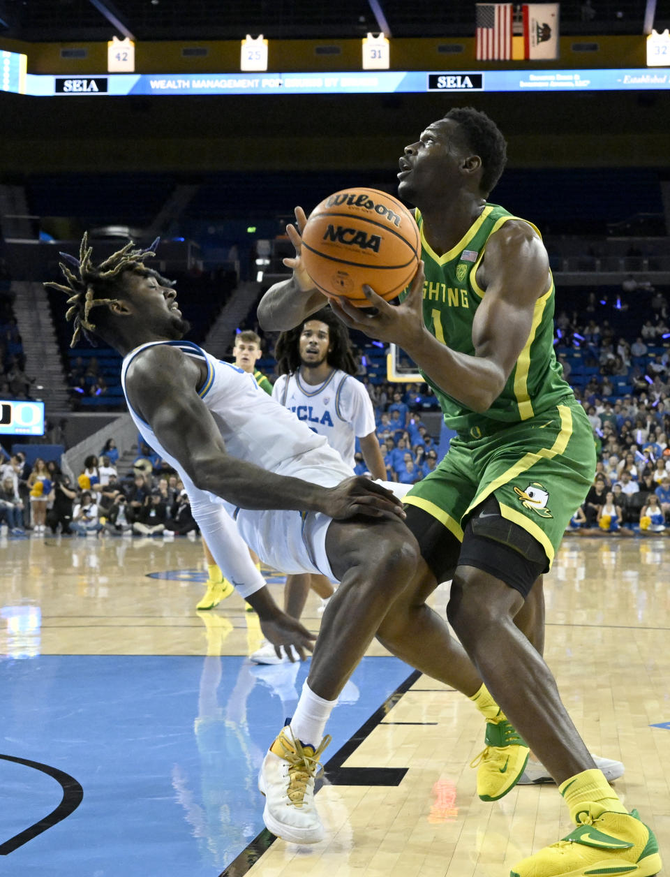 UCLA forward Kenneth Nwuba, left, is fouled by Oregon center N'Faly Dante, right, during the first half an NCAA college basketball game Sunday, Dec. 4, 2022, in Los Angeles. (AP Photo/John McCoy)