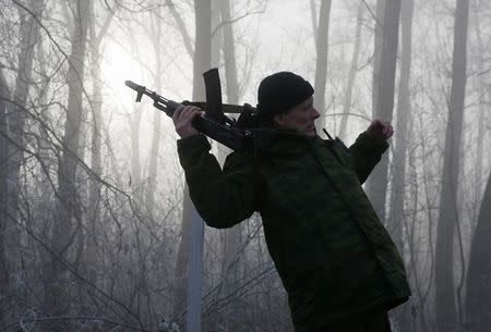 A pro-Russian rebel re-adjusts his AK machine gun outside of the town of Panteleimonovka, northeast of Donetsk, in this December 14, 2014 file photo. REUTERS/Maxim Shemetov/Files