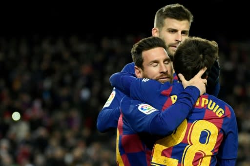 Lionel Messi (L) is congratulated by Riqui Puig after scoring Barcelona's winning goal against Granada